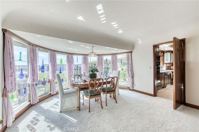 dining room with baseboards, carpet floors, a chandelier, and tile patterned flooring
