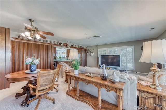living room with ceiling fan and carpet