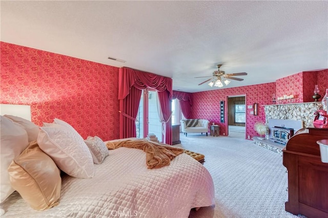 bedroom featuring wallpapered walls, carpet floors, a textured ceiling, and a ceiling fan