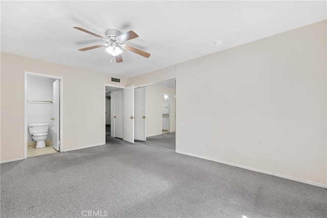 unfurnished bedroom with carpet, baseboards, ensuite bath, and ceiling fan