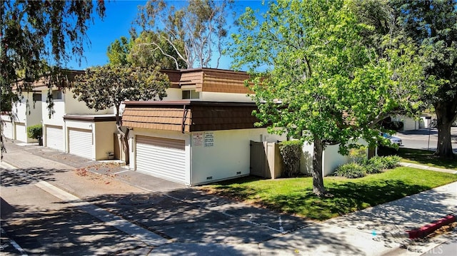 view of front of house featuring driveway, stucco siding, and a garage