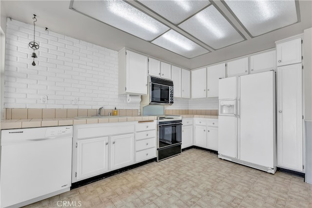 kitchen featuring white appliances, light floors, a sink, white cabinets, and decorative backsplash