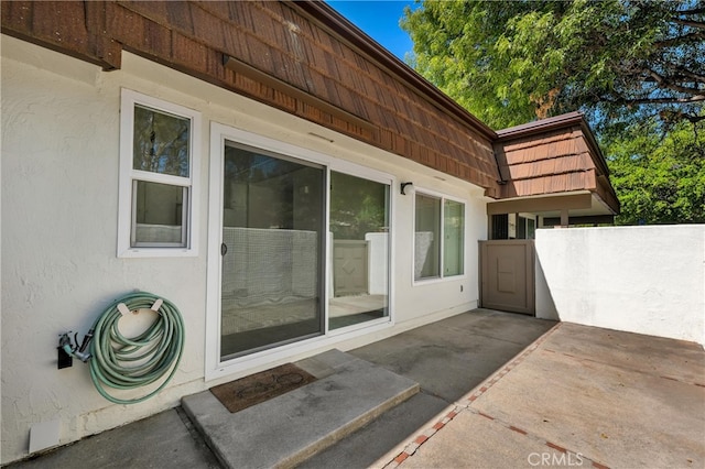 property entrance featuring a patio and stucco siding