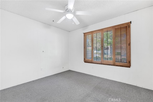 carpeted spare room with a ceiling fan and a textured ceiling