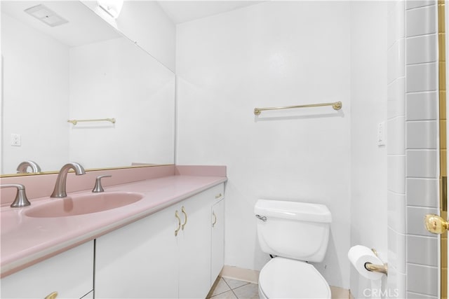 bathroom with toilet, vanity, and tile patterned floors