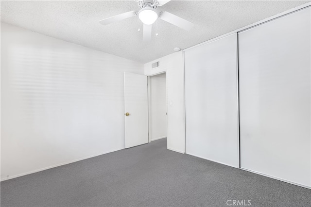 unfurnished bedroom with a textured ceiling, carpet, a closet, and ceiling fan