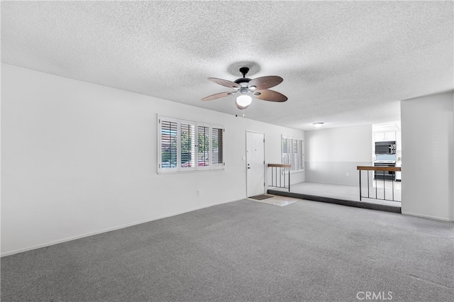 unfurnished room with a ceiling fan, a textured ceiling, carpet floors, and baseboards