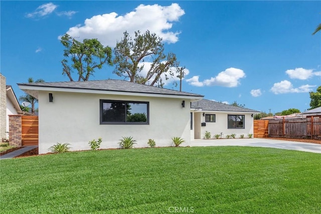 view of front of home featuring stucco siding, driveway, and roof with shingles