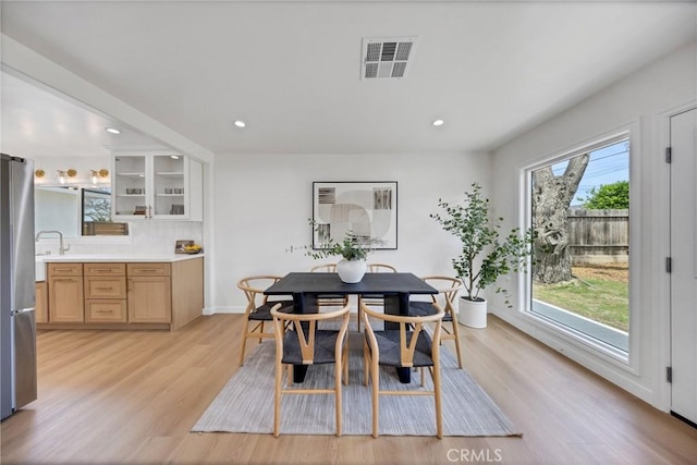 dining room featuring plenty of natural light, light wood-style floors, recessed lighting, and baseboards