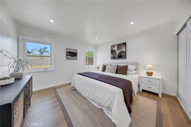 bedroom with light wood finished floors, baseboards, and recessed lighting