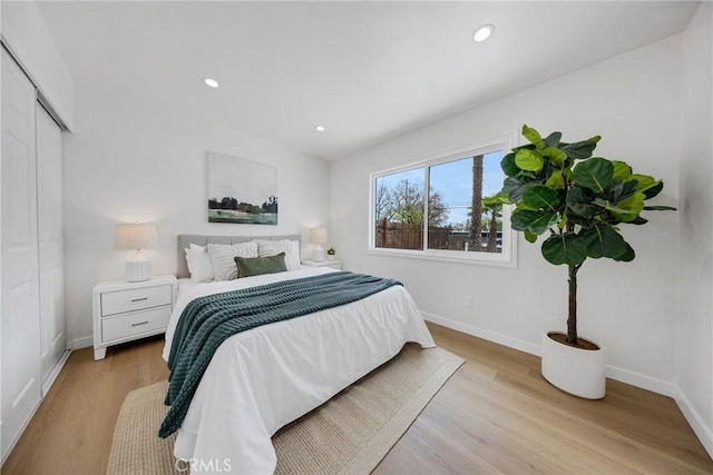 bedroom featuring baseboards, recessed lighting, and light wood finished floors