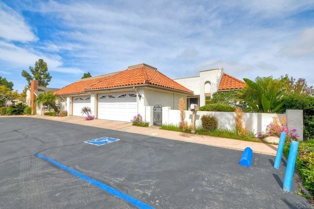 3579 Twilight Ln, Oceanside, CA 92056 - view of front facade featuring a tiled roof, stucco siding, fence, a garage, and a gate