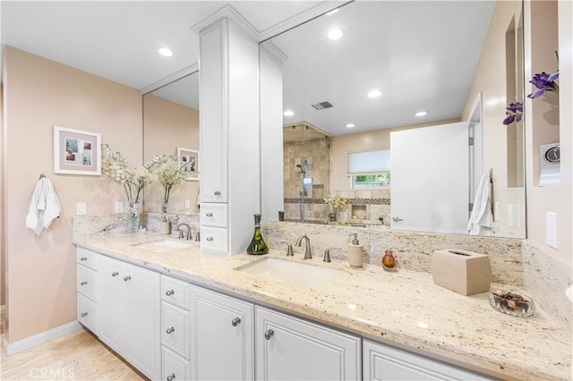 full bath with tiled shower, double vanity, baseboards, and recessed lighting
