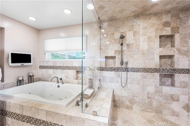 bathroom featuring a whirlpool tub and a tile shower