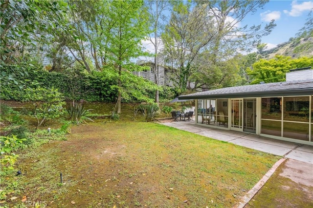 view of green lawn with a patio