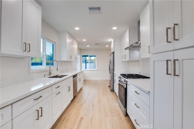 14704 Germain St, Mission Hills San Fernando, CA 91345 - kitchen with stainless steel appliances, a sink, light wood-style floors, white cabinets, and baseboards