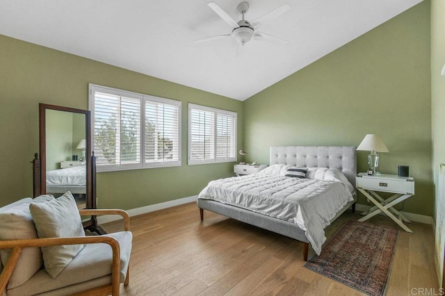 bedroom with vaulted ceiling, baseboards, wood finished floors, and ceiling fan