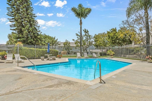 community pool featuring a patio area and fence