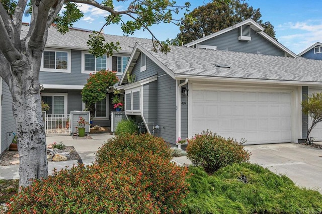 view of front of house featuring a shingled roof, a garage, and driveway