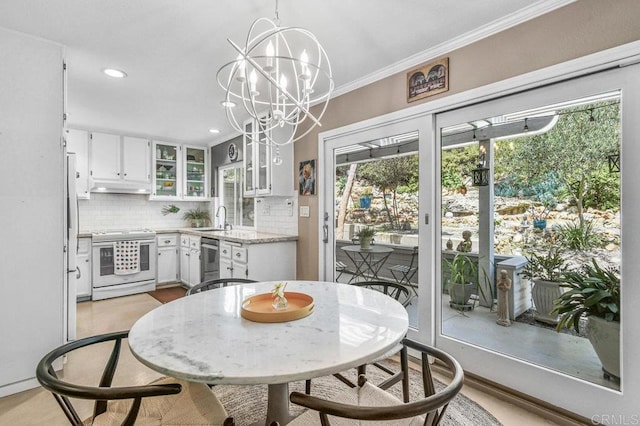 dining room with ornamental molding, recessed lighting, and a chandelier