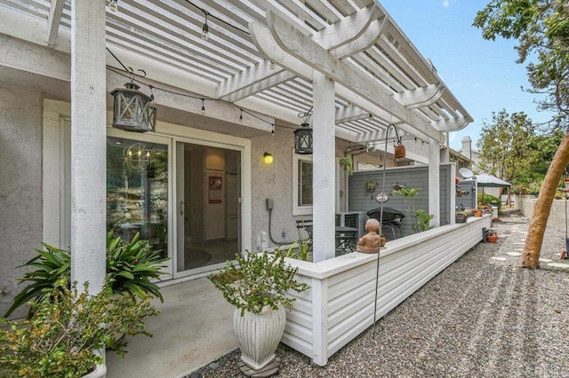 doorway to property with a pergola, stucco siding, and a patio area