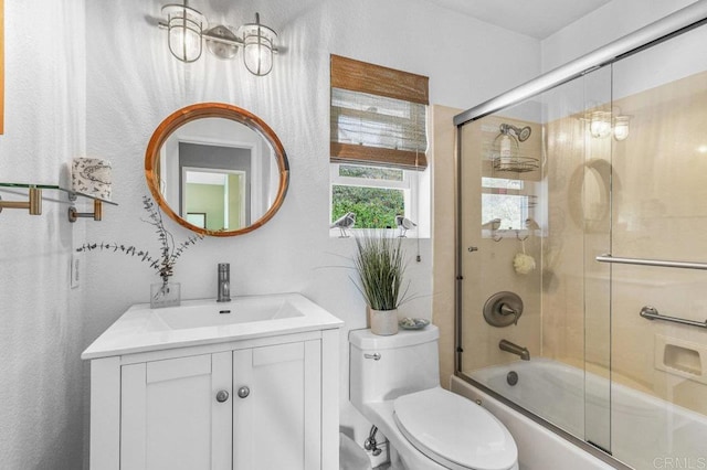 full bath featuring vanity, enclosed tub / shower combo, and toilet