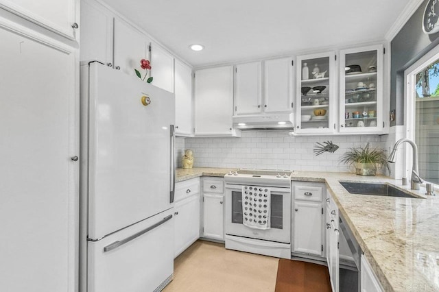 kitchen featuring white appliances, a sink, under cabinet range hood, white cabinets, and backsplash