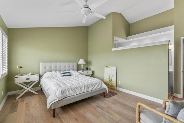 bedroom with wood finished floors, baseboards, ceiling fan, multiple windows, and high vaulted ceiling