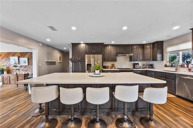 340 Terry Way, La Habra, CA 90631 - kitchen featuring stainless steel appliances, under cabinet range hood, a sink, dark brown cabinets, and dark wood-type flooring