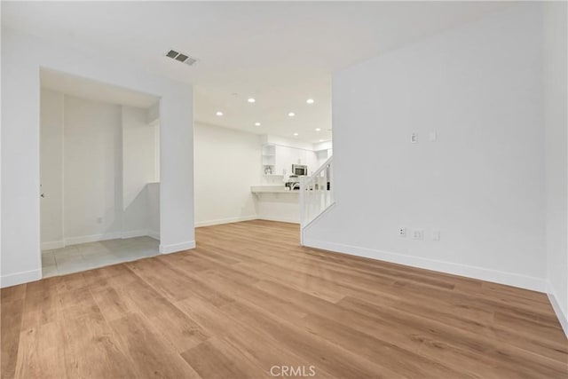 281 N Mar Vista Ave Unit 23, Pasadena, CA 91106 - unfurnished living room featuring light wood-style floors, baseboards, recessed lighting, and stairs