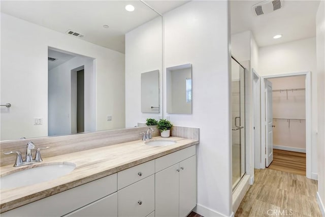 281 N Mar Vista Ave Unit 23, Pasadena, CA 91106 - bathroom with a shower stall, double vanity, a walk in closet, wood finished floors, and baseboards