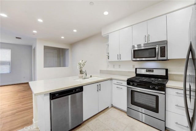 281 N Mar Vista Ave Unit 23, Pasadena, CA 91106 - kitchen featuring appliances with stainless steel finishes, a peninsula, light countertops, white cabinets, and a sink
