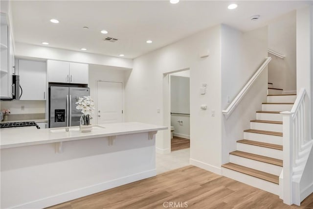 281 N Mar Vista Ave Unit 23, Pasadena, CA 91106 - kitchen featuring appliances with stainless steel finishes, light countertops, a peninsula, a breakfast bar area, and recessed lighting