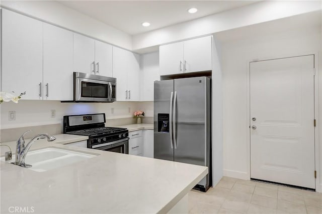 281 N Mar Vista Ave Unit 23, Pasadena, CA 91106 - kitchen with stainless steel appliances, a sink, light countertops, light tile patterned flooring, and white cabinetry