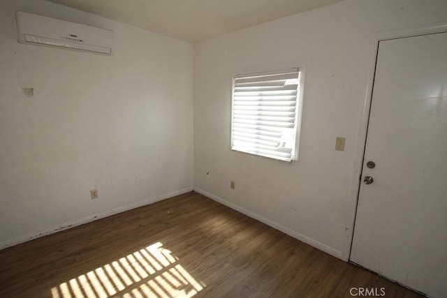 404 N 4th Ave, Barstow, CA 92311 - empty room featuring a wall mounted AC, wood finished floors, and baseboards