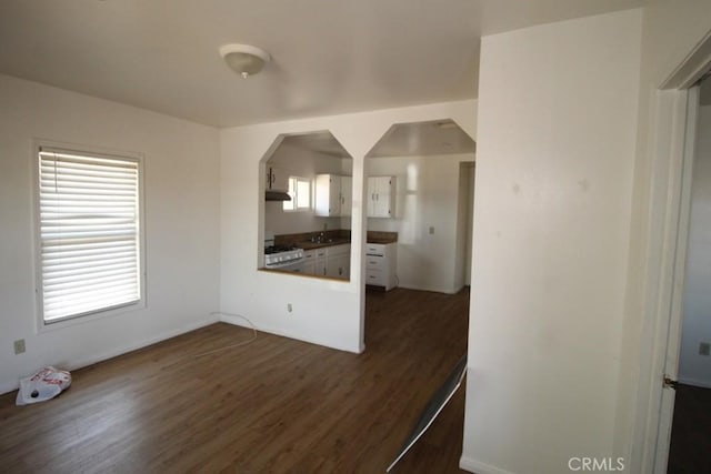 404 N 4th Ave, Barstow, CA 92311 - kitchen featuring dark wood-type flooring, a sink, range, a peninsula, and arched walkways