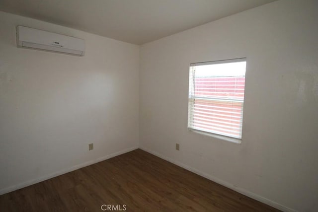 404 N 4th Ave, Barstow, CA 92311 - unfurnished room with wood finished floors, a wall mounted AC, and baseboards