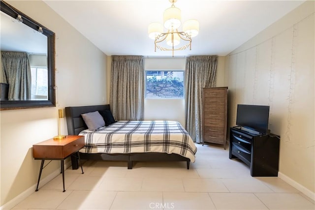 bedroom featuring a chandelier and baseboards