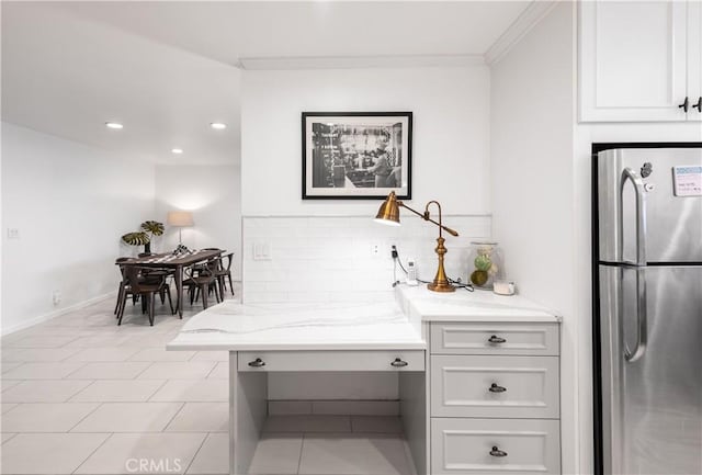 kitchen with freestanding refrigerator, backsplash, recessed lighting, baseboards, and light stone countertops