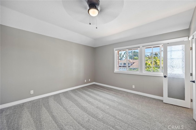 carpeted empty room featuring baseboards and ceiling fan