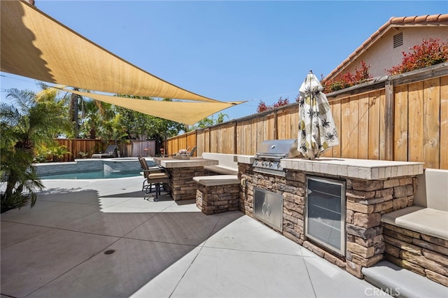 view of patio / terrace with an outdoor kitchen, grilling area, and a fenced backyard