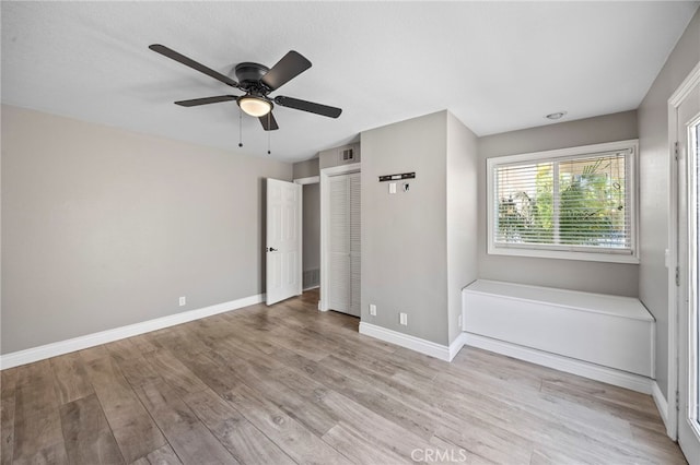 unfurnished bedroom with light wood-style flooring, baseboards, and a ceiling fan