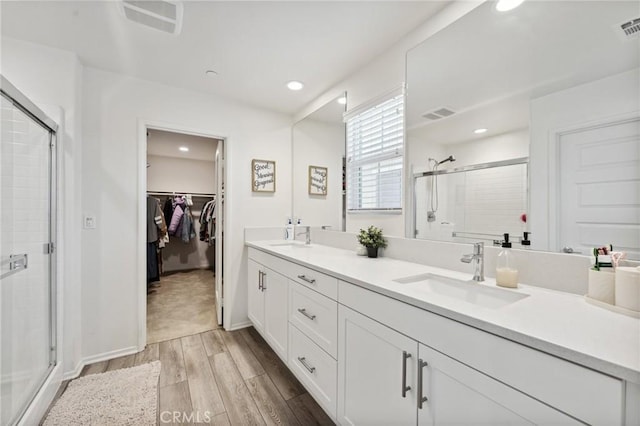 148 Camden Ct, Perris, CA 92571 - full bath with wood finished floors, a shower stall, double vanity, a walk in closet, and recessed lighting