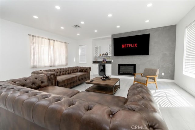 43250 Lago Brezza Dr, Indio, CA 92203 - living room featuring wine cooler, recessed lighting, wood finished floors, a large fireplace, and baseboards