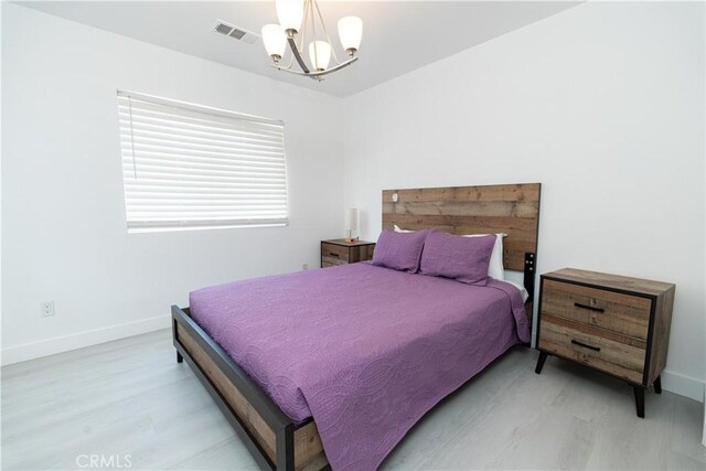 43250 Lago Brezza Dr, Indio, CA 92203 - bedroom with a chandelier, baseboards, and light wood finished floors