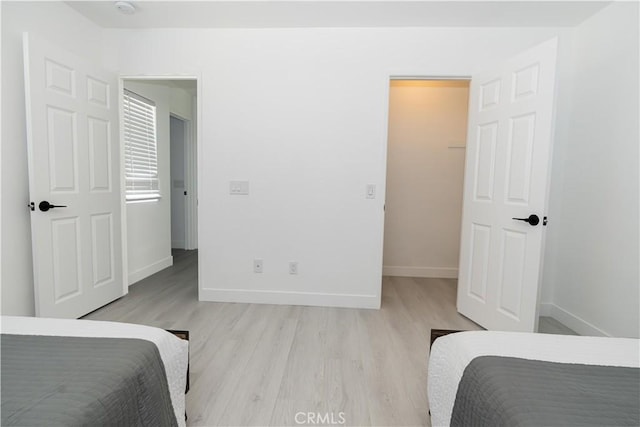 43250 Lago Brezza Dr, Indio, CA 92203 - bedroom with light wood finished floors, baseboards, and a walk in closet