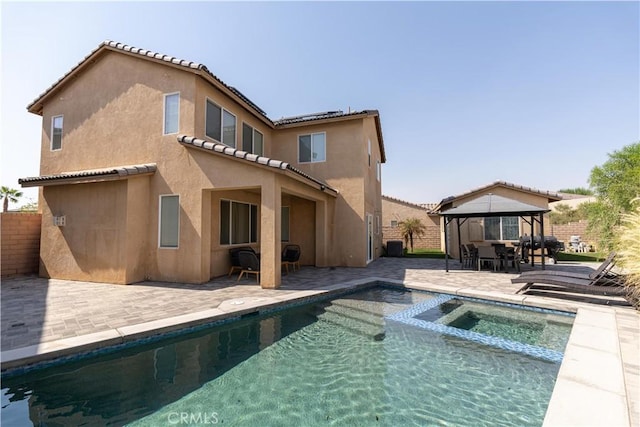 43250 Lago Brezza Dr, Indio, CA 92203 - rear view of house with a gazebo, a patio area, stucco siding, a pool with connected hot tub, and a tile roof