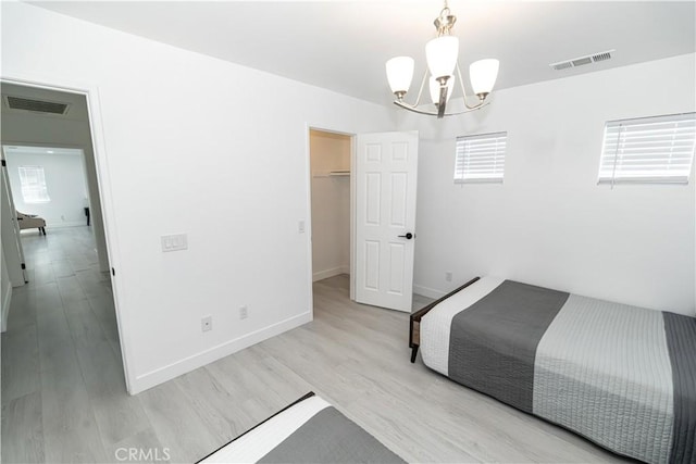43250 Lago Brezza Dr, Indio, CA 92203 - unfurnished bedroom with a chandelier, wood finished floors, baseboards, and a walk in closet