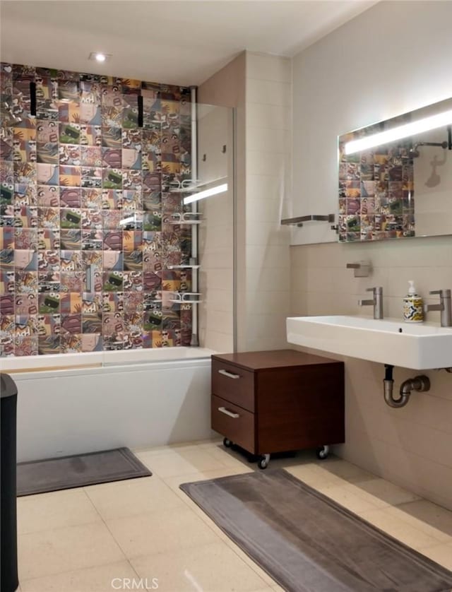 bathroom with a sink, tile walls, and a tub