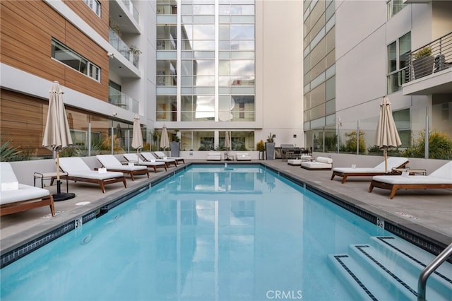 community pool with an outdoor hangout area and a patio area